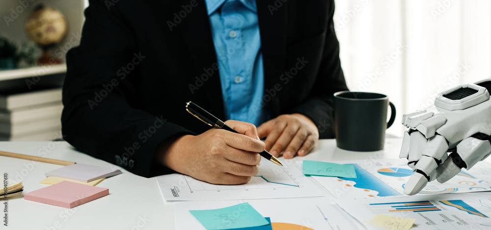 Poster a business professional engages in data analysis using a robotic hand, with charts and notes around 