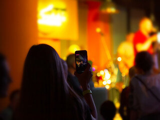 Person recording concert with smartphone