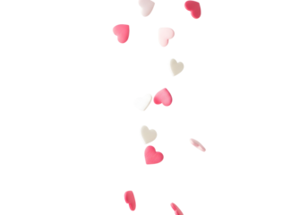 Delightful heart-shaped sprinkles gently falling, creating a whimsical cascade of sweetness, perfect for enchanting celebrations and adding a touch of romance to any festive culinary creation.