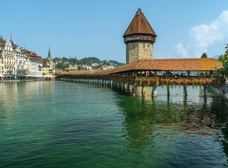 The Kapellbrücke ('Chapel Bridge') a wooden footbridge over river Reuss in the city of Lucerne in Switzerland in a sunny day.