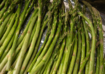 Cooked asparagus on a metal baking sheet. Roasted green vegetable for salad