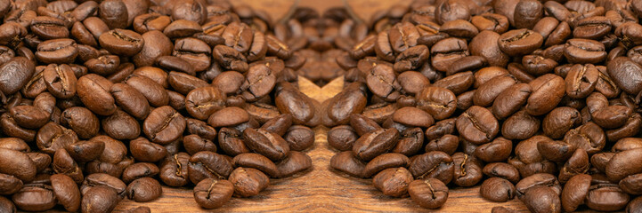 Dark brown whole coffee beans on wood background with copyspace