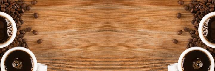 Hot coffee cup and coffee beans on brown background top view