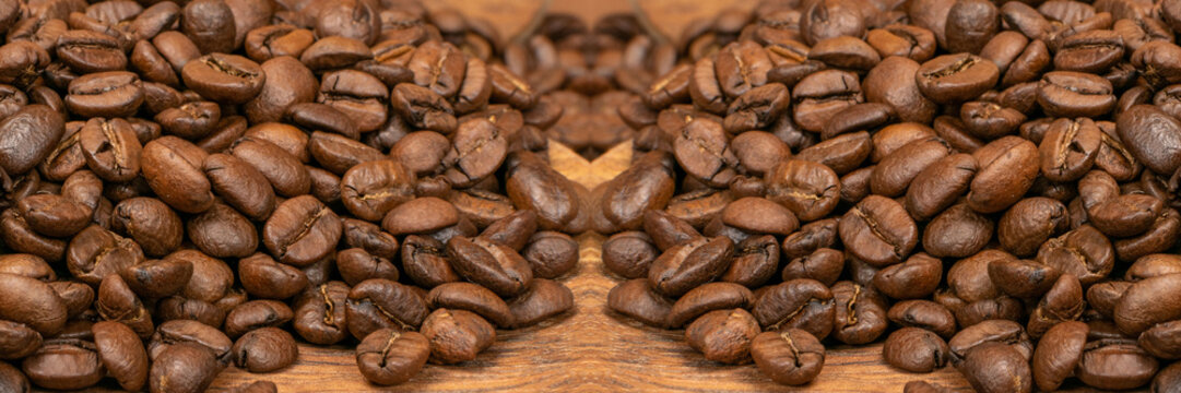 Dark brown whole coffee beans on wood background with copyspace