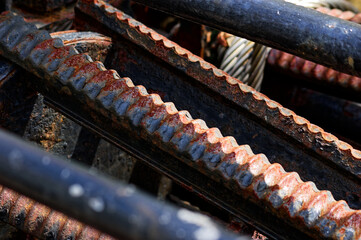 Thickly rusted, textured chain links with vibrant reds, oranges, and blue highlights, part of a...