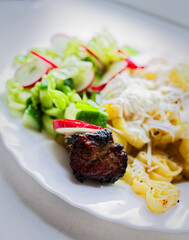 Discover a mouthwatering plated meal with grilled steak, crispy cheese fries, and fresh salad. The steak is perfectly seared and seasoned with visible grill marks, paired with golden-brown, cheesy