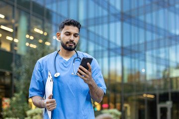 Healthcare worker checking phone while outside a modern building