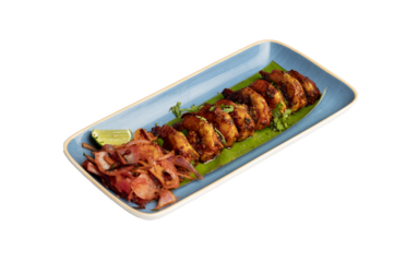 Prawns chili fry on a banana leaf in a blue plate with salad, coated in semolina, tossed with onion, tomato, green chilies, and flavored with toddy vinegar.