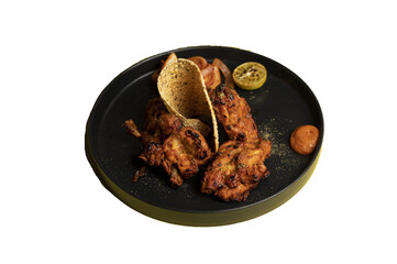 Tandoori Chicken—marinated in yoghurt and spices, roasted in a clay oven, served with papad and onion salad, isolated on transparent background for culinary projects.