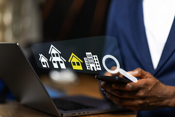 African man browsing real estate listings on a phone, searching for a new home.
