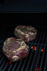 Huge fresh raw steak on BBQ gas grill with searing hos fire under neath