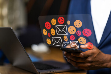 African businessman receiving negative emails on smartphone, online harassment, spam, and bad...