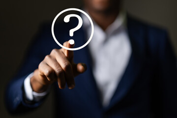 African Businessman drawing glowing question mark. Concept for help, support, and information....
