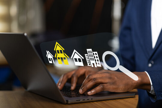 Real Estate, African man browsing real estate listings online on his laptop computer, searching for a new home.