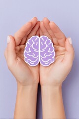 Hands protecting purple paper brain on lavender background