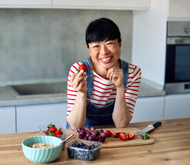 Portrait of a healthy young asian woman enjoying delicious fruit and cereal salad breakfast bowl at...