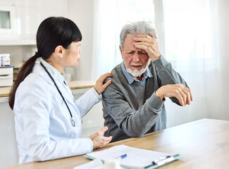 Portrait of a female doctor and senior man patient with a headache at her doctor's office in clinic