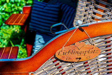 Beach chair with a wooden sign at side as decoration. “Lieblingsplatz” is the German word for favorite location.