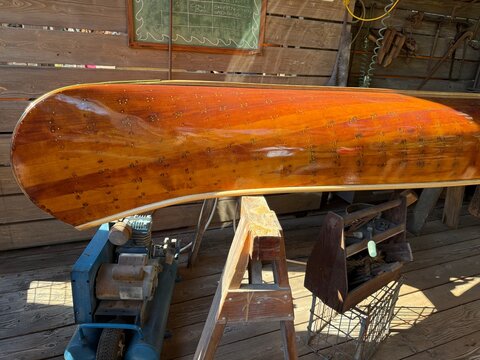Canoes Lined Up: Multiple canoes, often colorful, lined up on a shore or rack, ready for paddling or storage.