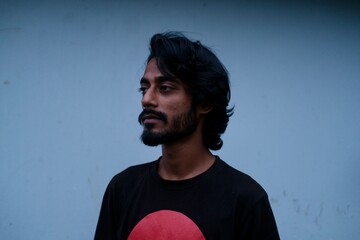 Young man portrait with hair style and blue wall background