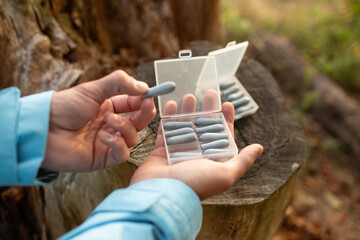 Hand holding a blister pack of white suppositories. Concept of pharmacy, treatment, and medical...