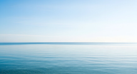 A wide-angle shot of calm blue ocean meeting a clear bright sky, minimalist composition, neat horizon line, clean natural background.