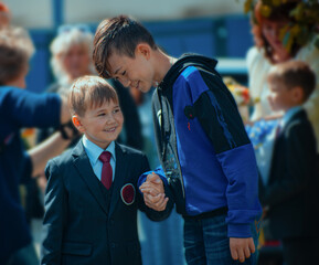 The school year begins. The older brother takes the younger brother to school.