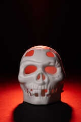 White plastic Skull on a Dramatic Red and Black Background
