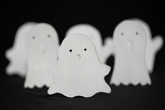 Grupo de fantasmitas blancos de papel con fondo negro y desenfoque