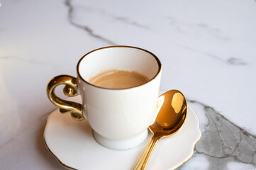 Cup of coffee with golden spoon on marble table in Neufchateau, Belgium
