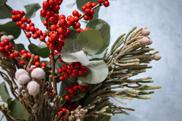 A vibrant botanical floral arrangement featuring red berries, eucalyptus. Close-up of a beautiful...