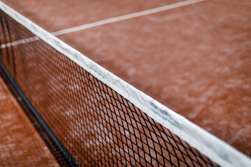 Padel court view with net and red clay surface ready for matches in a sports facility