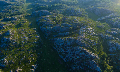 Deep shadowed ridges and golden coastline light.