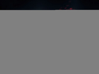 Closeup of fingers typing on a laptop keyboard, illuminated by red code. Suggests hacking, cybersecurity, programming, or data analysis. Dark, dramatic style.