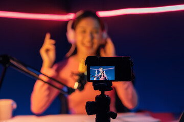 Selective focus camera screen in host channel of beautiful Asian listening the music on social...