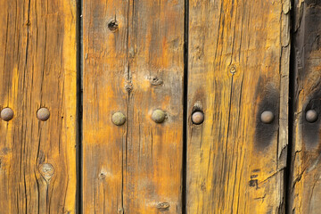 Naklejka premium Detailed view of an old wooden surface with rustic rivets, showcasing the natural wooden grain and weathered texture, providing an aesthetic touch of vintage charm
