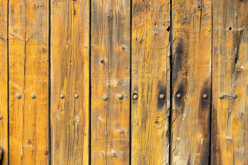 Detailed view of an old wooden surface with rustic rivets, showcasing the natural wooden grain and weathered texture, providing an aesthetic touch of vintage charm