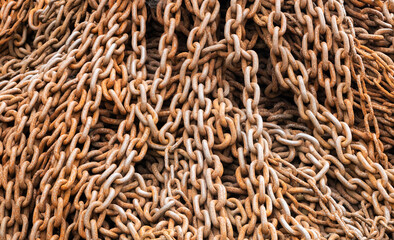 Detailed view of a dense collection of heavily rusted iron chains, showcasing texture and...
