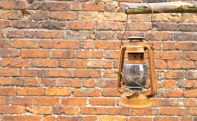 Rustic Oil Lantern Hanging Against A Weathered Brick Wall Background