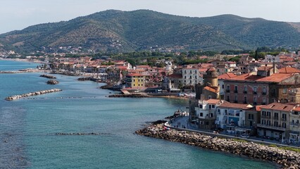 Fototapeta premium Il Lungomare di Santa Maria di Castellabate, località turistica del sud Italia. Vista aerea della spiaggia e del borgo marinaro del Cilento. 4K