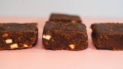 Decadent, fudgy chocolate brownies presented on a vibrant pink and blue background. Ideal for bakery advertising, dessert blogs, or social media content. Professional food photography with bold colors