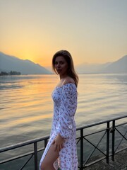young girl watching sunrise near lake Como