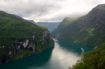 Mountain landscape with cloudy sky. Beautiful nature Norway. Geiranger fjord. Seven Sisters Waterfall