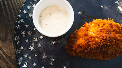 Golden-brown crispy fried chicken pieces served with a creamy garlic sauce on a beautifully presented plate. Perfect for restaurant menus, food blogs, and advertising campaigns. Professional food phot