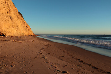 A piece of rock illuminated by sunlight on a sandy beach