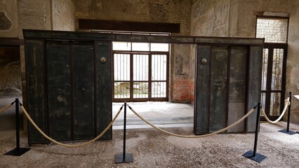 Herculaneum, Italy - 9 January 2025. Restored wooden sliding doors, likely from a wealthy house or...