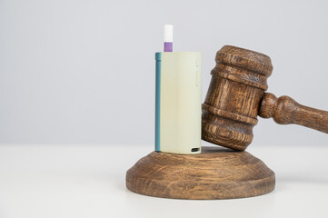Judge's gavel and e-cigarette. Smoking ban. Tobacco heating systems. 