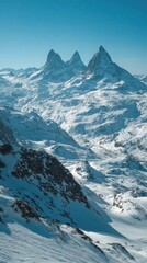 Snowy mountain peaks pierce a vibrant blue sky.  Vast snow-capped mountain ranges stretch into the distance