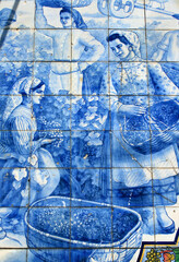 Portugal, Typical old vintage Portuguese azulejos - blue and white ceramic tiles depicting a rural scene. Women in traditional costume harvesting grapes.