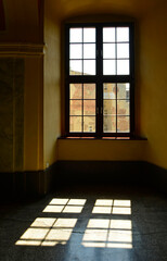 duże okno w holu, światło słoneczne padajace przez okna starego budynku na kamienną poszadzkę, sunlight coming through the window reflected in the stone floor  © kateej